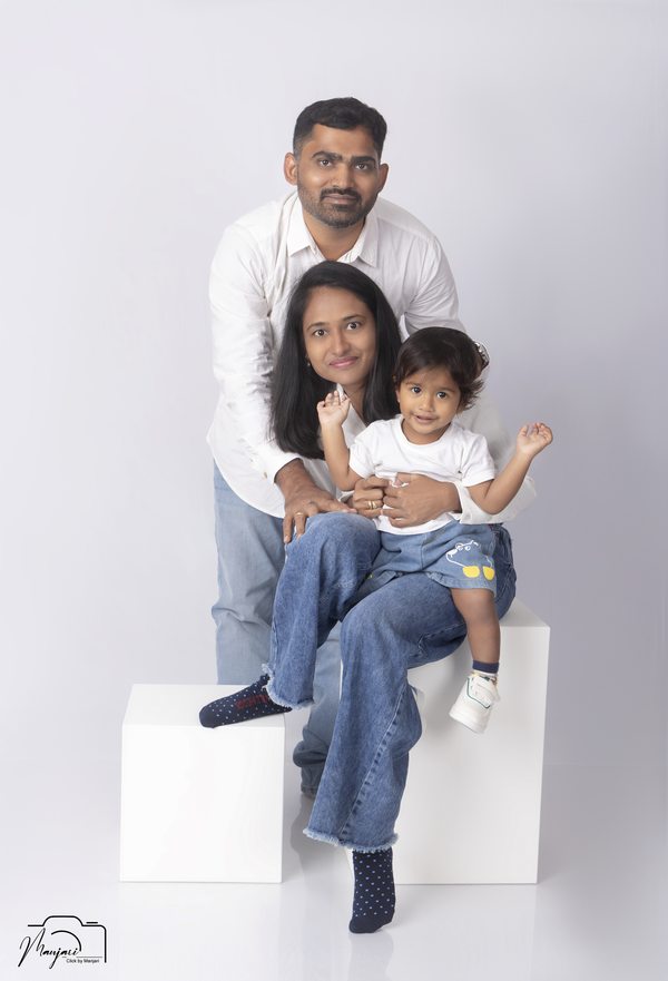 Parents and their young child in a bright studio portrait