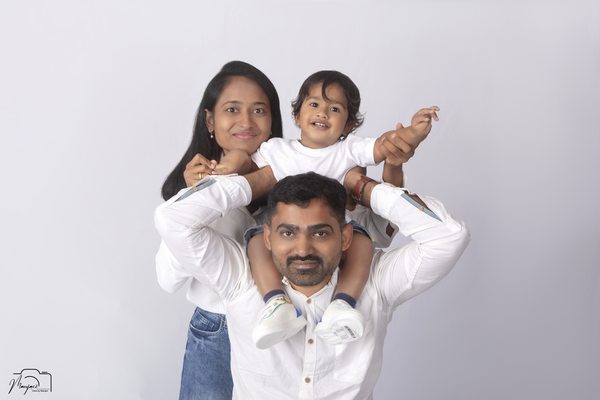 Playful family portrait with a child on her fathers shoulders