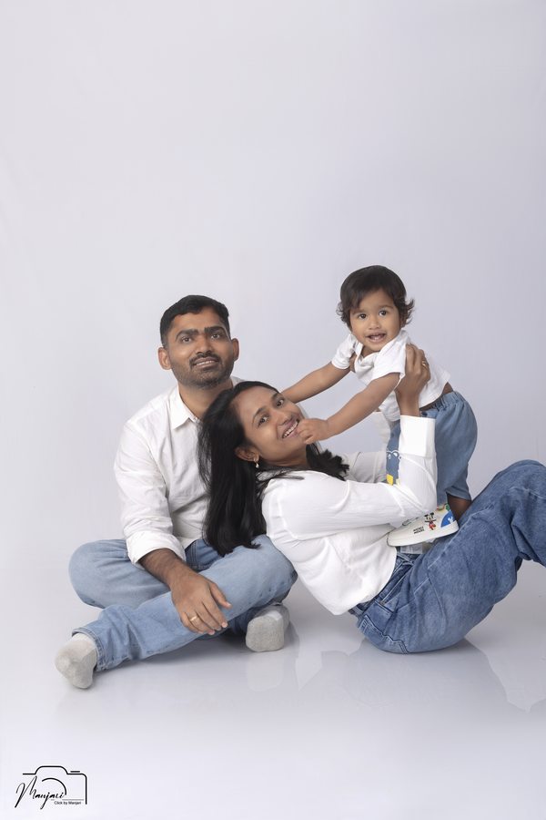 Parents seated with their toddler in a bright studio