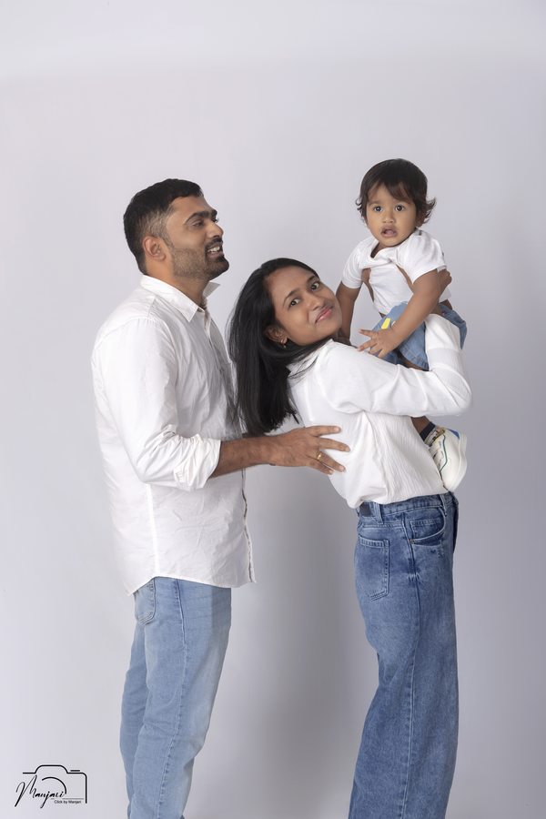 Parents kissing their child in a standing studio portrait