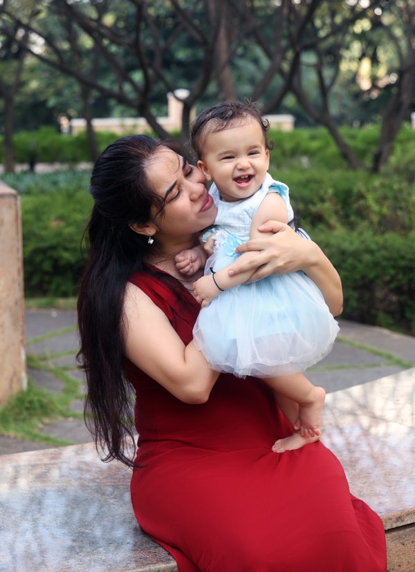 Mother kissing her smiling baby outdoors