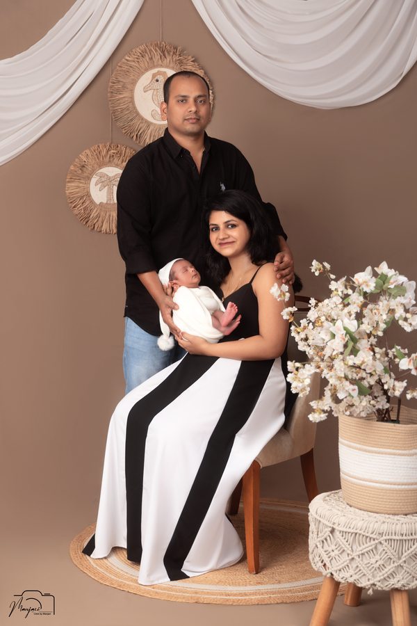 Family in formal black and white outfits at a studio set