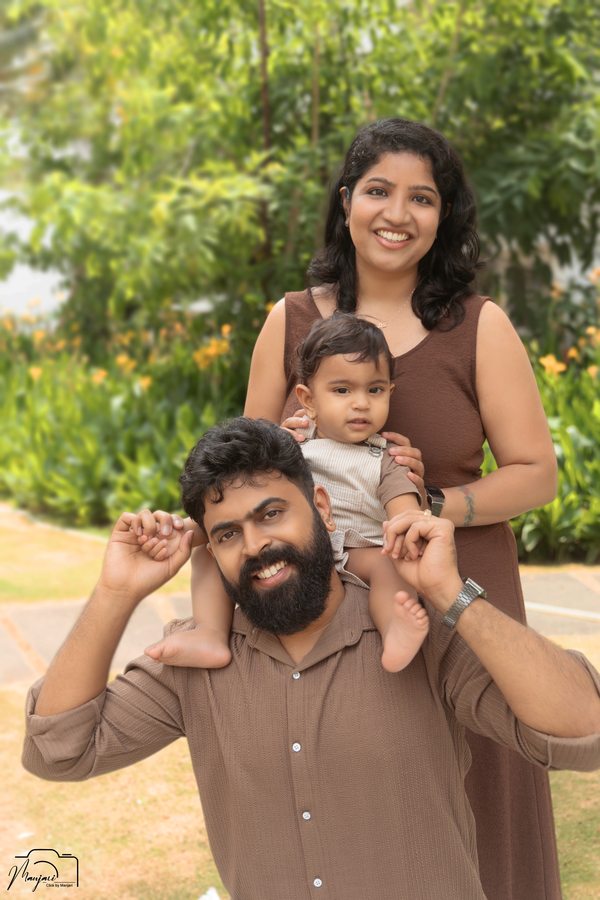 Family outdoors with their baby on the fathers shoulders