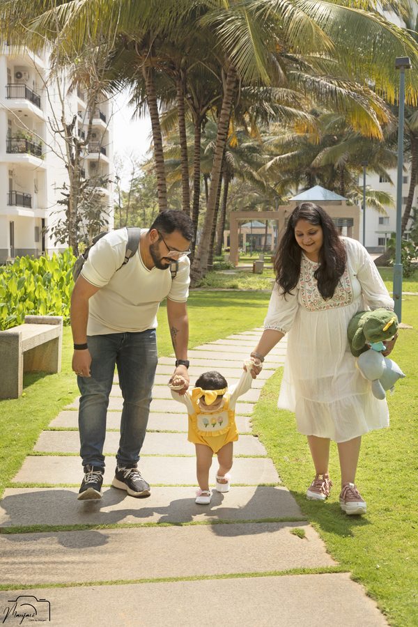 Family walking hand in hand through a garden