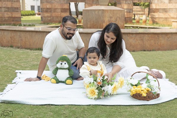 Family enjoying a picnic blanket moment with their toddler