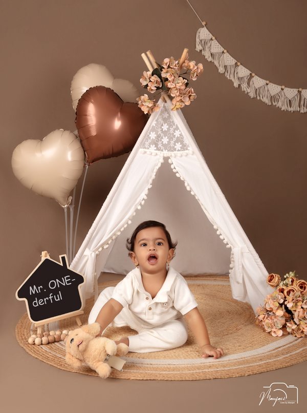 Laughing toddler at a warm neutral birthday set
