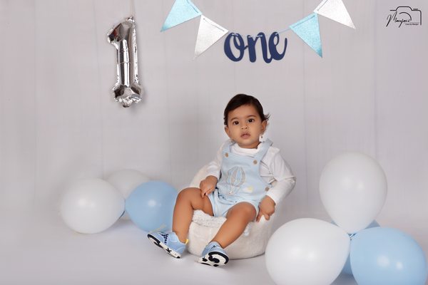 Baby in blue at a first-birthday balloon set