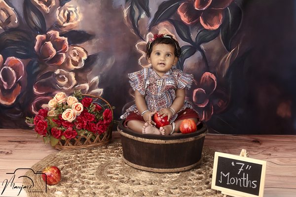 Baby smiling in a vintage floral studio set