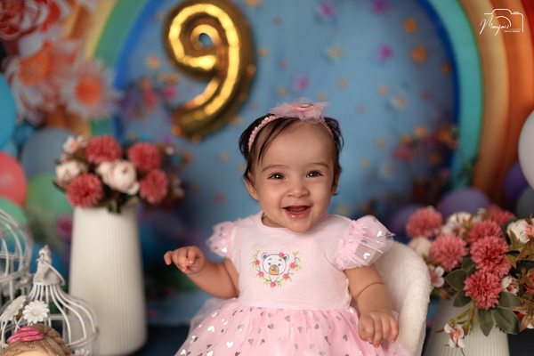 Smiling baby at a colourful nine-month milestone set