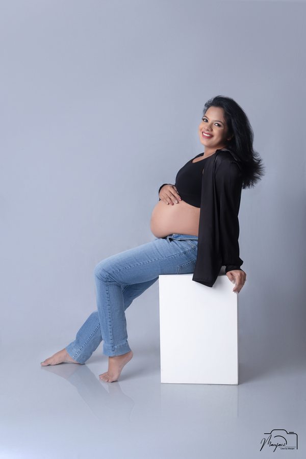 Relaxed studio maternity portrait in denim and black