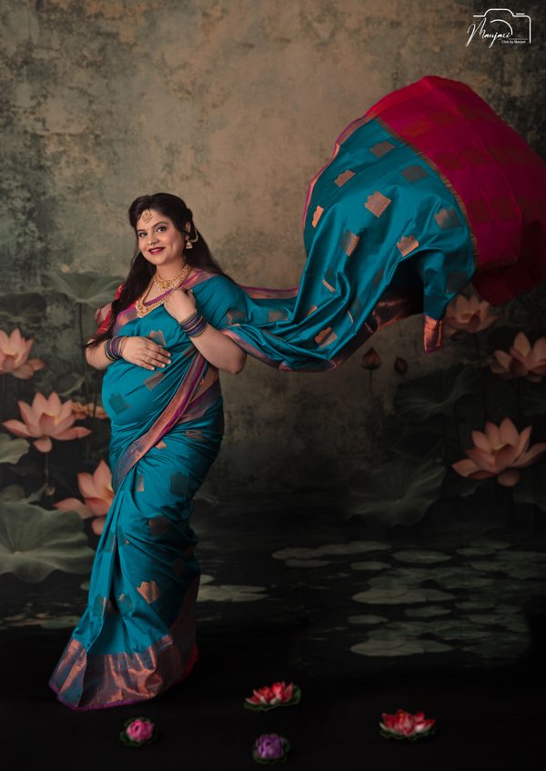 Expectant mother in a turquoise sari with flowing fabric