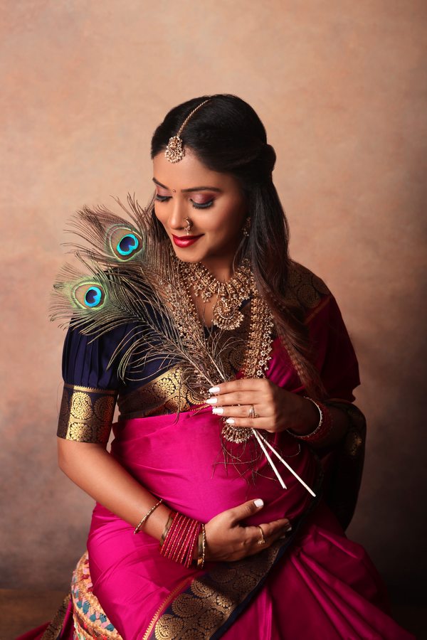 Traditional maternity portrait with peacock feathers