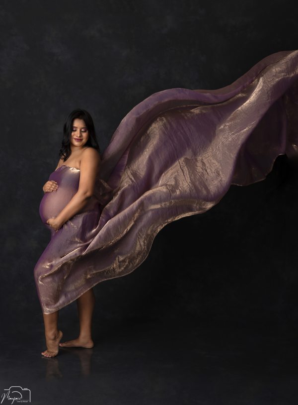 Dramatic maternity portrait with flowing lilac fabric