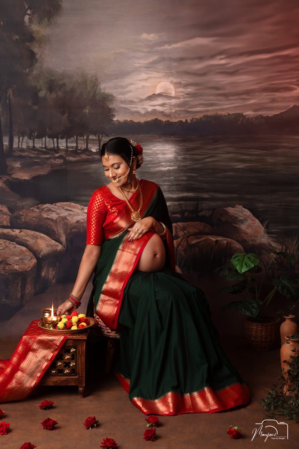 Traditional maternity portrait in a red and green sari