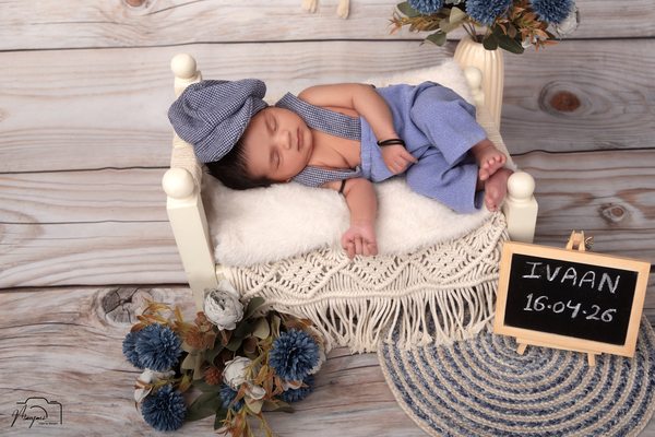 Newborn sleeping in blue on macrame bedding