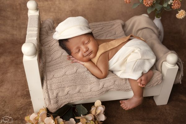 Close portrait of a newborn sleeping on a miniature bed