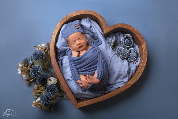 Sleeping newborn in a blue heart-shaped floral set