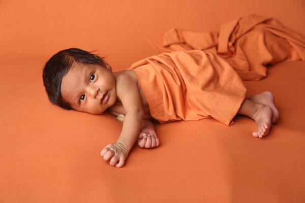 Baby sleeping against a warm terracotta backdrop